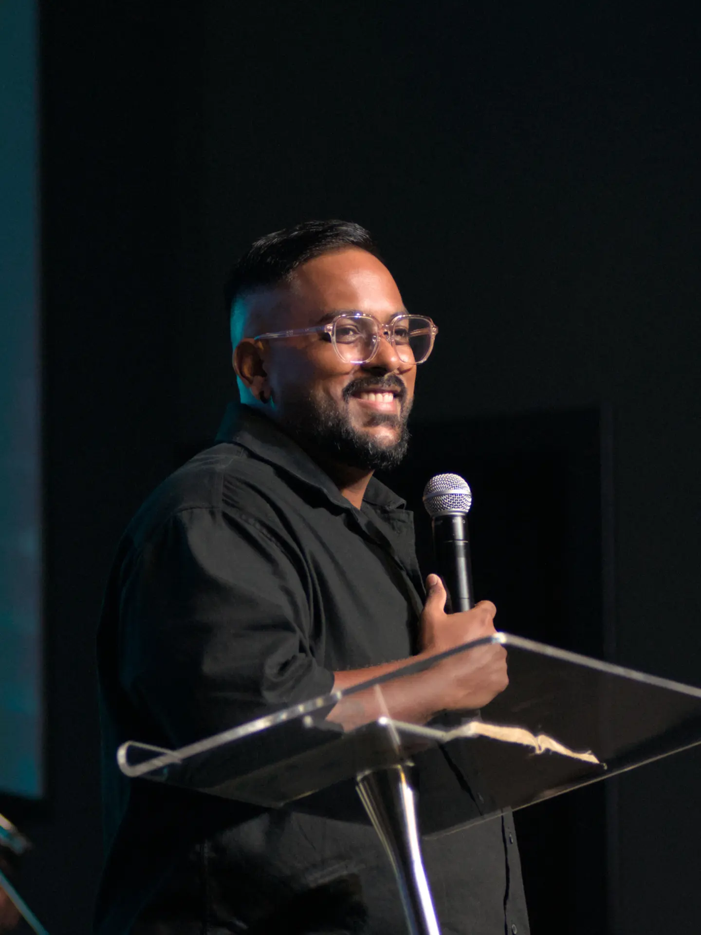 Ps. Ben Rajendram speaking at a podium
